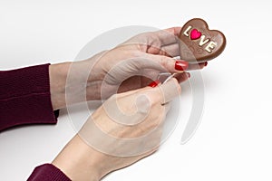 woman holding a chocolate candy in the form of a heart