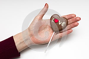 woman holding a chocolate candy in the form of a heart