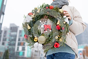 Woman Holding Christmas Wreath in Snow