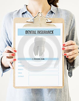 woman holding clipboard with dental insurance
