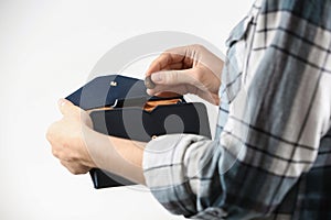 Woman holding coin into wallet on light background. Money savings