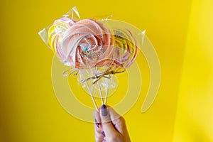 A woman holding a colorful candy in hand.