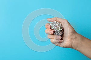 Woman holding colorful slime on blue background. Antistress toy