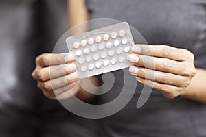 Woman holding combined oral contraceptive pill.