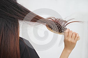 Woman holding combing with brush and clean long hair, Haircare concept