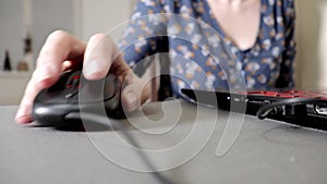 Woman holding a computer mouse, clicking and scrolling, close up. Lady working on computer at home