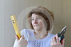 woman is holding construction tools