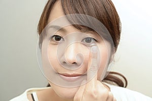 Woman holding contact lens