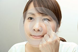 Woman holding contact lens