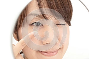 Woman holding contact lens on index finger