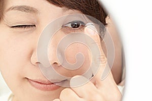 Woman holding contact lens on index finger