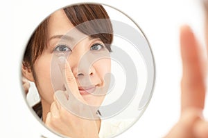 Woman holding contact lens on index finger