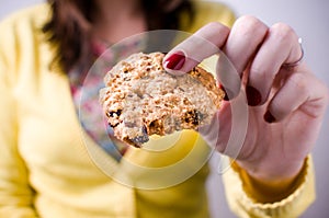 Woman holding cookie in one hand