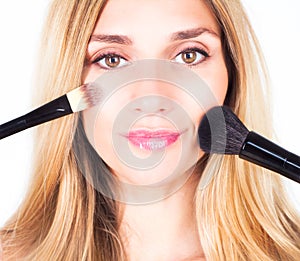 Woman is holding cosmetic brushes. Make-up