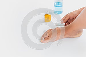 Woman holding cotton with alcohol cleaning wound on her feet.