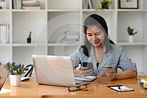 Woman holding credit card making banking online or shopping online on her smart phone.