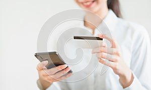 Woman holding credit card with shopping online on smartphone and enter the payment code for the product.