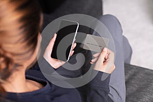 Woman holding credit card and smartphone