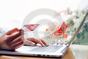 Woman holding credit card and typing keyboard laptop doing shopping online concept.