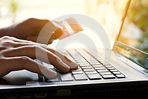 Woman holding credit card and typing keyboard on laptop with shopping online.