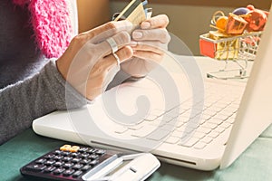 Woman holding credit cards and using laptop computer for shopping online, Thanksgiving Day or Christmas