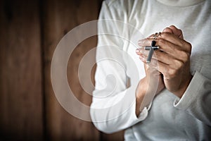 Woman holding a cross in her hands and praying. Pray for blessings from God. Concept of religion faith