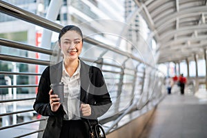 Woman holding a cup of coffee in city photo