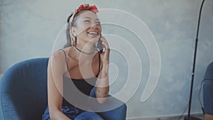 Woman holding a cup of coffee laughs as she talks on her cellphone