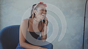 Woman holding a cup of coffee laughs as she talks on her cellphone