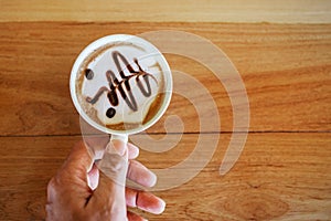 Woman holding cup of coffee on table