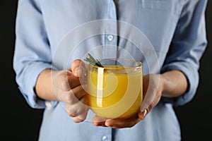 Woman holding cup of immunity boosting drink in hands, closeup