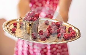 Woman holding a cup of raspberries