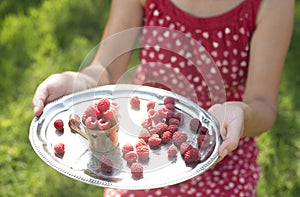 Woman holding a cup of raspberries