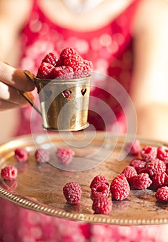 Woman holding a cup of raspberries