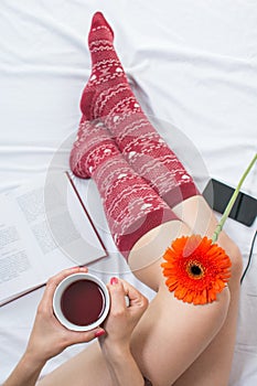 Woman holding a cup of tea in bed