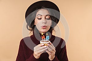 Woman holding cupcake with happy birthday candles