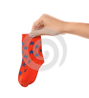 Woman holding cute child sock on white background