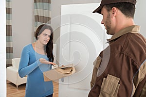 Woman holding damaged package from delivery man
