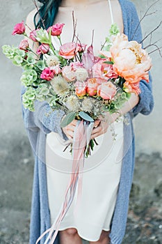 A woman holding a decorative bouquet of flowers in her hands