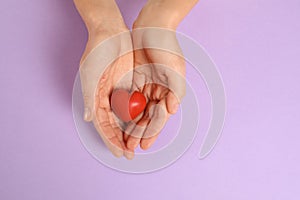 Woman holding decorative heart on color background