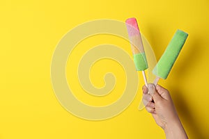 Woman holding delicious ice creams against color background