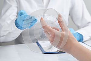 Woman holding diaphragm vaginal contraceptive ring at the doctor's appointment, closeup