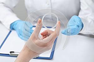 Woman holding diaphragm vaginal contraceptive ring at the doctor\'s appointment, closeup