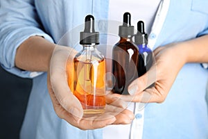 Woman holding different bottles with essential oils