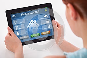 Woman Holding Digital Tablet With Remote Home Control System