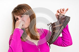 Woman holding dirty stinky shoes