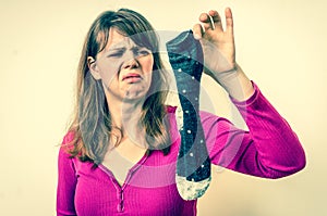 Woman holding dirty stinky socks - retro style