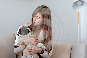 Woman holding dog pug breed and sleep in her arm relax