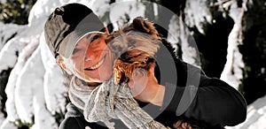 Woman holding a dog in the snow