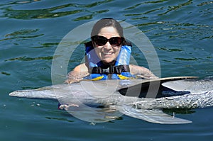 Woman holding a dolphin.